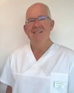 Kiropraktor i Limbra klinikk smiler og har på seg hvit klinikkuniform.