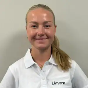 Kvinne i Limbra-uniform smiler mot kamera.