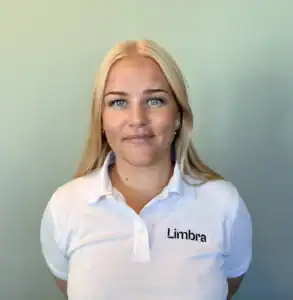 Kvinne i Limbra-polo med blå øyne og blondt hår.