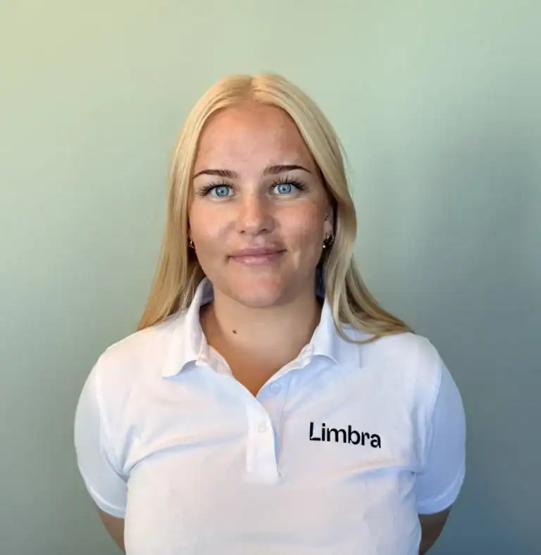 Kvinne i Limbra-polo med blå øyne og blondt hår.