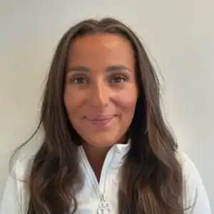 Portrett av Ines Nibler, smilende kvinne med langt brunt hår.