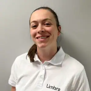 Kvinne i hvit Limbra-polo smiler mot kamera.