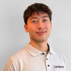 Ung mann i hvit Limbra-polo mot en lys bakgrunn.