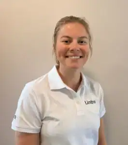 Kvinne i hvit Limbra-polo smiler mot kamera.