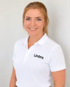 Kvinne i hvit Limba-polo smiler mot kamera.