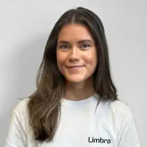 Kvinne med langt brunt hår smiler mot kameraet.