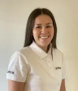 Kvinne i hvit Limbra-polo smiler mot kamera.